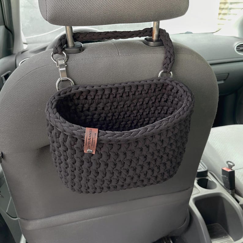In the photo is a basket crocheted from t-shirt yarn, which can be hung on the headboard of the car seat. The strap is attached with a strong metal button. Suitable for collecting small trash or for storing napkins, water or other personal items.