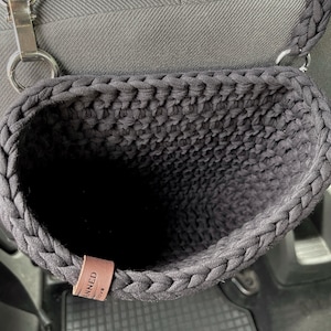 In the photo is a basket crocheted from t-shirt yarn, which can be hung on the headboard of the car seat. The strap is attached with a strong metal button. Suitable for collecting small trash or for storing napkins, water or other personal items.