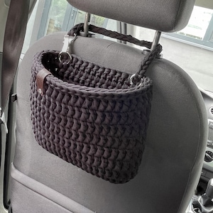In the photo is a basket crocheted from t-shirt yarn, which can be hung on the headboard of the car seat. The strap is attached with a strong metal button. Suitable for collecting small trash or for storing napkins, water or other personal items.