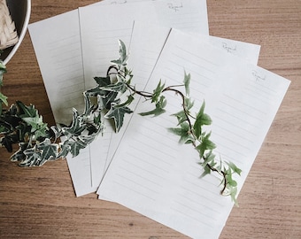May include: Four blank lined sheets of paper with the word "Respond" written on three of the sheets. The sheets are arranged in a fan shape on a wooden surface. A green vine with leaves is draped over the sheets.