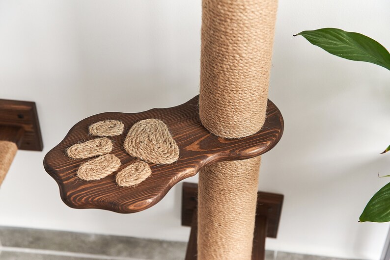 May include: A brown wooden cat scratching post with a sisal rope covering and a paw-shaped platform. The platform has a rope paw print design.