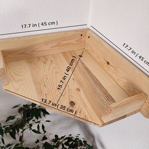 May include: A wooden corner shelf with a chevron pattern, measuring 17.7 inches by 17.7 inches by 15.7 inches.