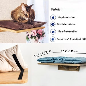 May include: A wooden cat shelf with a brown cushion and a beige cushion. The shelf is 11.4 inches wide and 17.7 inches long. The fabric is liquid-resistant, scratch-resistant, non-flammable, and Oeko Tex Standard 100.