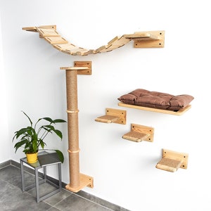Pu&ograve; includere: Un albero per gatti in legno con un ponte, un tiragraffi e diverse piattaforme. Le piattaforme sono ricoperte di corda di sisal e il ponte &egrave; fatto di assi di legno. L'albero per gatti &egrave; montato su una parete bianca.