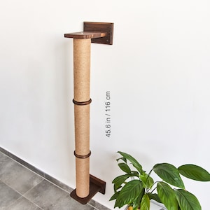 Pode incluir: Um arranhador de gato de parede feito de madeira e corda de sisal. O poste tem 116 cm de altura.