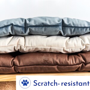May include: Three stackable cushions in brown, beige, and blue velvet. The cushions are scratch-resistant.