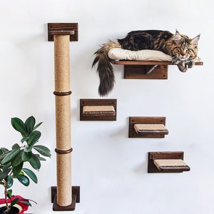 May include: A wall-mounted cat tree with a scratching post, a platform, and two shelves. The cat tree is made of wood and has a brown finish. The scratching post is covered in sisal rope. The platform and shelves are covered in a beige fabric. A cat is lying on the platform.