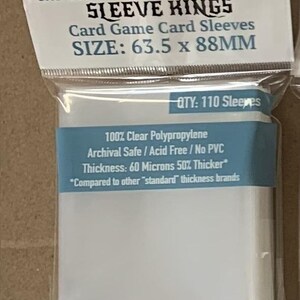 May include: Clear card game card sleeves in a plastic package. The package has the text "SLEEVE KINGS" and "SIZE: 63.5 x 88MM". The package also states "QTY: 110 Sleeves" and "100% Clear Polypropylene".