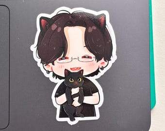 May include: A die-cut sticker featuring a cartoon illustration of a person with dark hair, cat ears, and glasses, holding a small black cat. The person wears a black shirt and small hoop earrings, while the cat has large yellow eyes.
