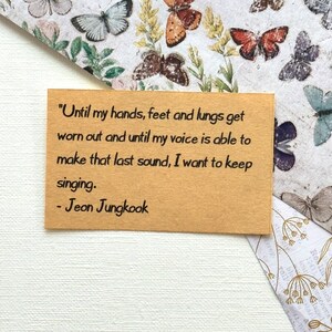 May include: A brown card with a quote from Jeon Jungkook, a South Korean singer. The quote reads, "Until my hands, feet and lungs get worn out and until my voice is able to make that last sound, I want to keep singing. - Jeon Jungkook"
