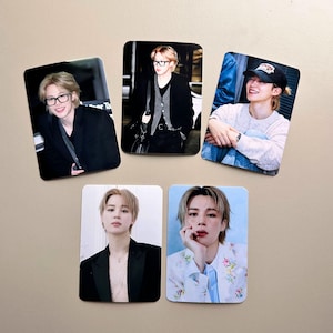 Peut inclure: Ensemble de cinq aimants photo rectangulaires. Chaque aimant présente une image différente d'une personne aux cheveux blonds. Les images montrent la personne dans diverses tenues et environnements, y compris des lunettes et une casquette de baseball.