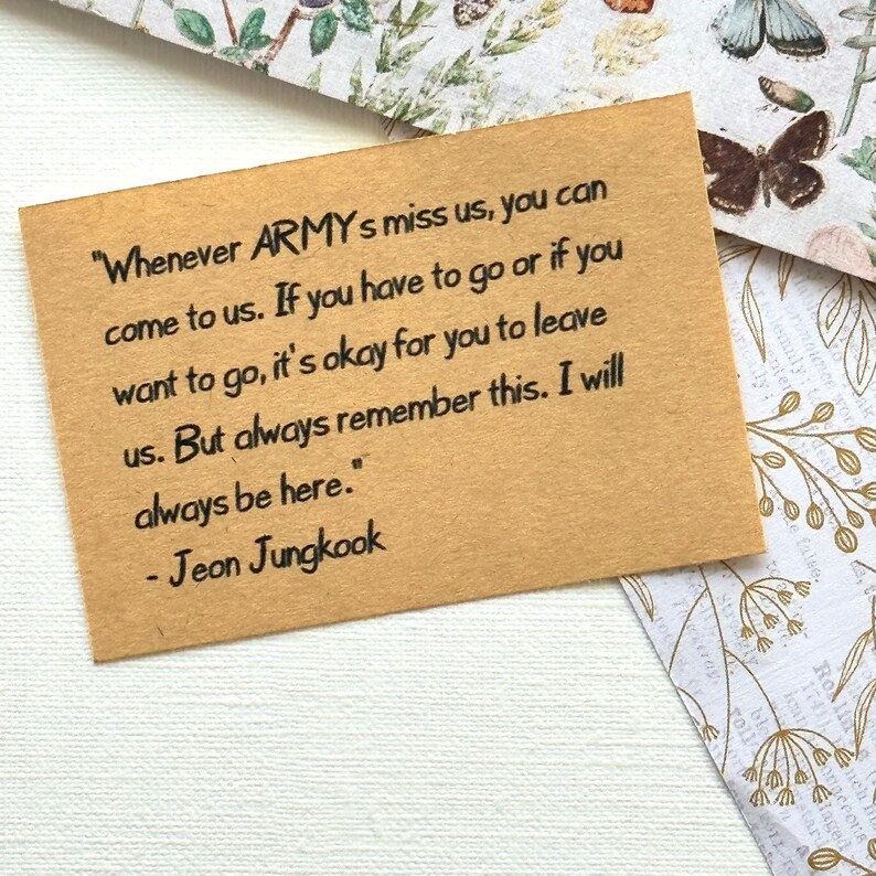 May include: A brown card with a handwritten message from a K-pop band member. The message reads, "Whenever ARMY's miss us, you can come to us. If you have to go or if you want to go, it's okay for you to leave us. But always remember this. I will always be here." - Jeon Jungkook