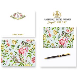 May include: A set of professionally printed notecards with a floral design featuring birds and pink ribbons. The notecards are printed on 110 lb. felt paper and include a matching envelope. The notecards are personalized with the name "Linda Adams" and a monogram.