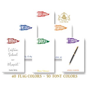 May include: A collection of white notepads with colorful pennant designs, including "Bulldogs," "Wildcats," "Hogs," "Ducks," "Gators," and "Tigers." The image also shows a pen and the text "Custom School or Mascot." The text "40 FLAG COLORS • 50 FONT COLORS" is also visible.
