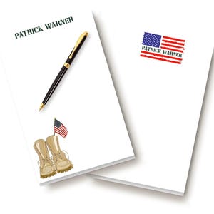 May include: White notepad with the name "PATRICK WARNER" printed in green. A black and gold pen rests on the notepad. A small American flag and a pair of tan combat boots are also depicted. The second notepad has an American flag graphic.