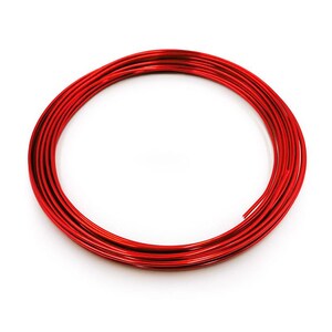 May include: A circular coil of shiny red wire, possibly for crafts or jewellery, sits against a white backdrop. The wire is neatly coiled, displaying its smooth, reflective surface and vivid colour. The image is well-lit, emphasising the wire's shape.