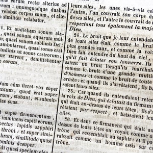 May include: Close-up of an open book with text in Latin and French. The pages are aged and yellowed, with visible text and a detailed layout. The text is in black ink.