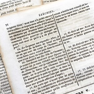 May include: Close-up of an open book with text in a foreign language. The pages are aged and yellowed, with visible text and chapter headings. The text appears to be from a religious text.