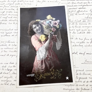 Années 1910 - Carte postale d'une jeune femme avec une corbeille de fleurs