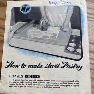 May include: A vintage black and white cookbook page titled "How to make short Pastry." The image shows a person preparing pastry on a board, with a rolling pin and a can of milk. The text includes a list of required utensils.