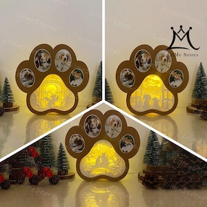 May include: A paw-shaped wooden photo frame with six circular photo slots and a cut-out scene of dogs at the Rainbow Bridge. The frame is illuminated from within, creating a warm glow. The frame is brown and has the text "Lilme Stores".