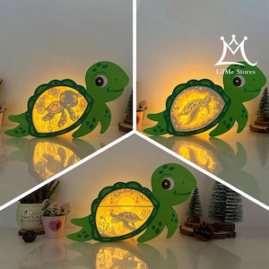 May include: Three green wooden turtle night lights with illuminated interiors. Each turtle has a different design inside its shell, including a turtle, a sunset, and a turtle with a smiling face. The text "LilMe Stores" is visible.