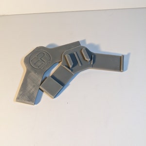 Pu&ograve; includere: Due pezzi di plastica grigia stampati in 3D con un logo che dice "WCFX" su uno dei pezzi.