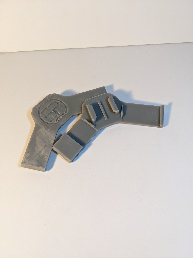 Pu&ograve; includere: Due pezzi di plastica grigia stampati in 3D con un logo che dice "WCFX" su uno dei pezzi.