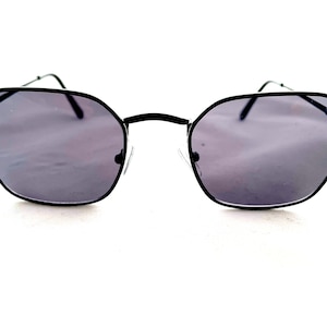 May include: Black octagon-shaped sunglasses with dark gray lenses.