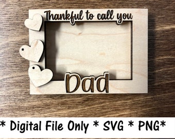 May include: A wooden picture frame with a cutout for a photo. The frame is decorated with three hearts and the text "Thankful to call you Dad".