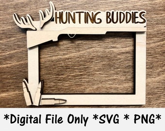 May include: A wooden picture frame with a rifle and antlers design. The frame says "Hunting Buddies" at the top.