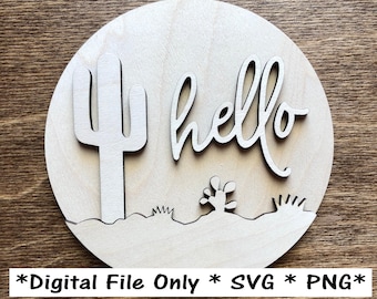 May include: A wooden round sign with a cutout of a cactus and the word "hello" in a cursive font. The sign has a desert theme with small cacti and grass cutouts.