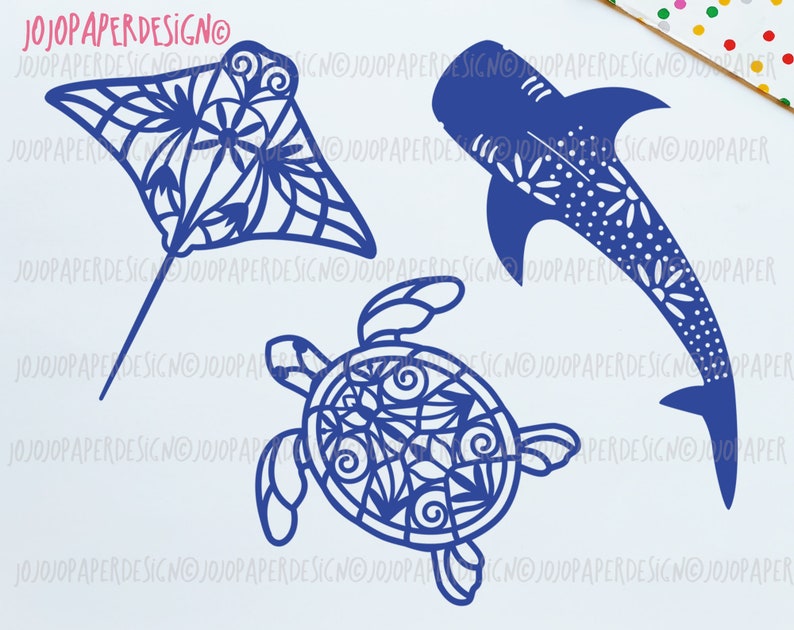 K&ouml;nnte beinhalten: Ein Set aus drei blauen Papierschnitten von Meerestieren: ein Mantarochen, ein Walhai und eine Meeresschildkr&ouml;te. Jede Ausschneidung hat ein detailliertes, kompliziertes Design.