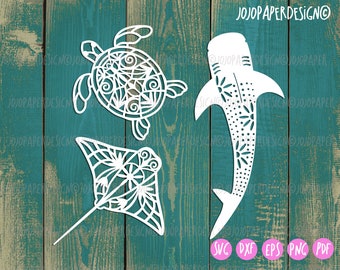 May include: White cut-out designs of a turtle, a manta ray, and a whale shark. The designs are intricate and detailed, with a mandala-like pattern. The designs are perfect for paper crafts, scrapbooking, and other creative projects.