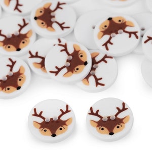 Könnte beinhalten: Eine Sammlung weißer runder Knöpfe mit einem braunen Rentiergesicht-Design. Die Knöpfe haben zwei Löcher.