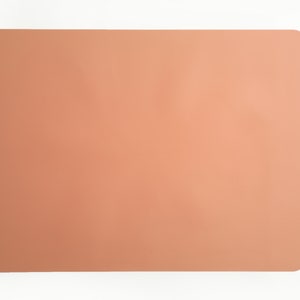 May include: A light peach-colored rectangular placemat.