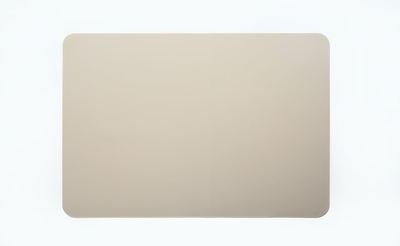 May include: A light beige rectangular placemat with rounded corners.