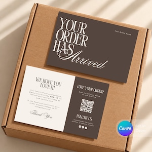 May include: A brown cardboard shipping box containing two printed cards. The top card is dark brown with white text reading YOUR ORDER HAS ARRIVED. The bottom card is split between cream and dark brown, featuring text and a QR code.