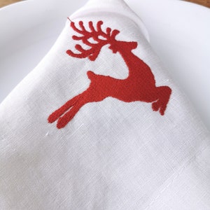Embroidered Christmas napkins for a gift. Linen white napkins with red embroidery for the festive table.Christmas reindeer napkins
