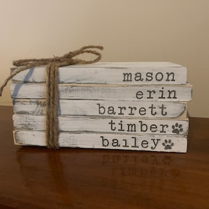 May include: A stack of five white painted wooden blocks with the names "mason", "erin", "barrett", "timber", and "bailey" written on them. Each block has a paw print on the bottom.