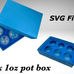 Könnte beinhalten: Eine blaue Pappbox mit Deckel, die für sechs 1 oz Töpfe ausgelegt ist. Die Box ist geöffnet und zeigt das Innere mit sechs runden Ausschnitten für die Töpfe. Der Text "SVG File" ist in der oberen rechten Ecke des Bildes sichtbar.