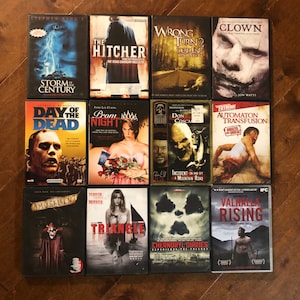 May include: A collection of 12 horror movie DVDs featuring titles like "The Hitcher", "Wrong Turn 2", "Clown", "Day of the Dead", "Prom Night", "Automaton Transfusion", "Amusement", "Triangle", "Chernobyl Diaries", and "Valhalla Rising".