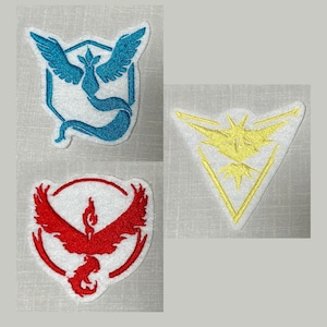 May include: Three embroidered patches featuring the Pokemon team logos: Valor (red), Mystic (blue), and Instinct (yellow).