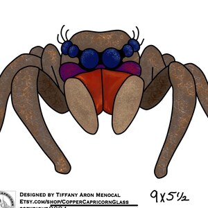 May include: A stained glass spider with brown legs, a purple and orange mouth, and blue eyes. The spider is 23 cm by 14 cm.