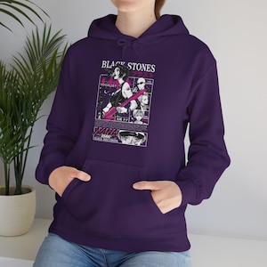 K&ouml;nnte beinhalten: Ein dunkelvioletter Kapuzenpullover mit einer Grafik aus der Manga-Serie "Nana". Die Grafik enth&auml;lt den Text "BLACK STONES" und Illustrationen von Charakteren. Der Hoodie hat eine Vordertasche und eine Kapuze mit Kordelzug.