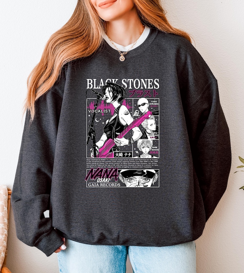 K&ouml;nnte beinhalten: Dunkelgraues Sweatshirt mit einer Manga-Illustration einer S&auml;ngerin, die eine rosa Gitarre spielt. Das Design enth&auml;lt den Text "BLACK STONES" und japanischen Text sowie "NANA OSAKI" und "GAIA RECORDS".