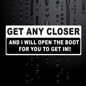 May include: A rectangular black and white sticker with the text "GET ANY CLOSER AND I WILL OPEN THE BOOT FOR YOU TO GET IN!!" The sticker is set against a black background with water droplets.