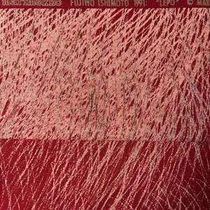 May include: Red fabric with a white, scribbled pattern. The top section is a lighter shade of red. The text "marimekko FUJIWO ISHIMOTO 1991: "LEPO"" is printed across the top in a red band.