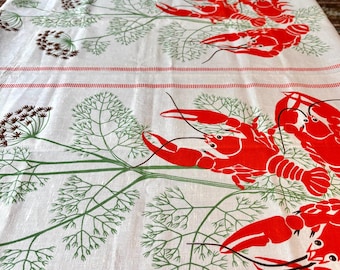 May include: White tablecloth with a repeating pattern of red crayfish, green dill sprigs, and brown seed heads. Red stripes border the top and bottom. The design is printed on a white linen fabric.