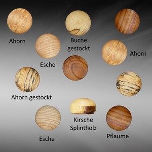 May include: A collection of wood samples in various colors and grains, including maple, beech, ash, cherry, and plum. The wood samples are labeled with their names in German.